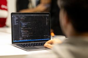 Student looking at computer screen with code