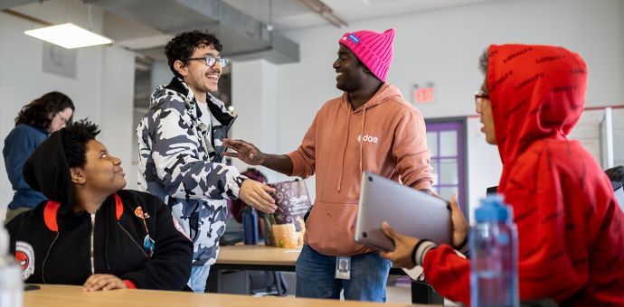 Group of dae students socializing and smiling in classroom