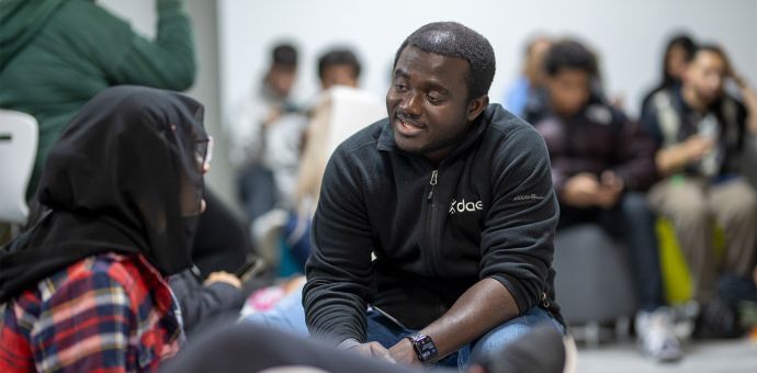 dae instructor smiling and speaking with dae student in classroom